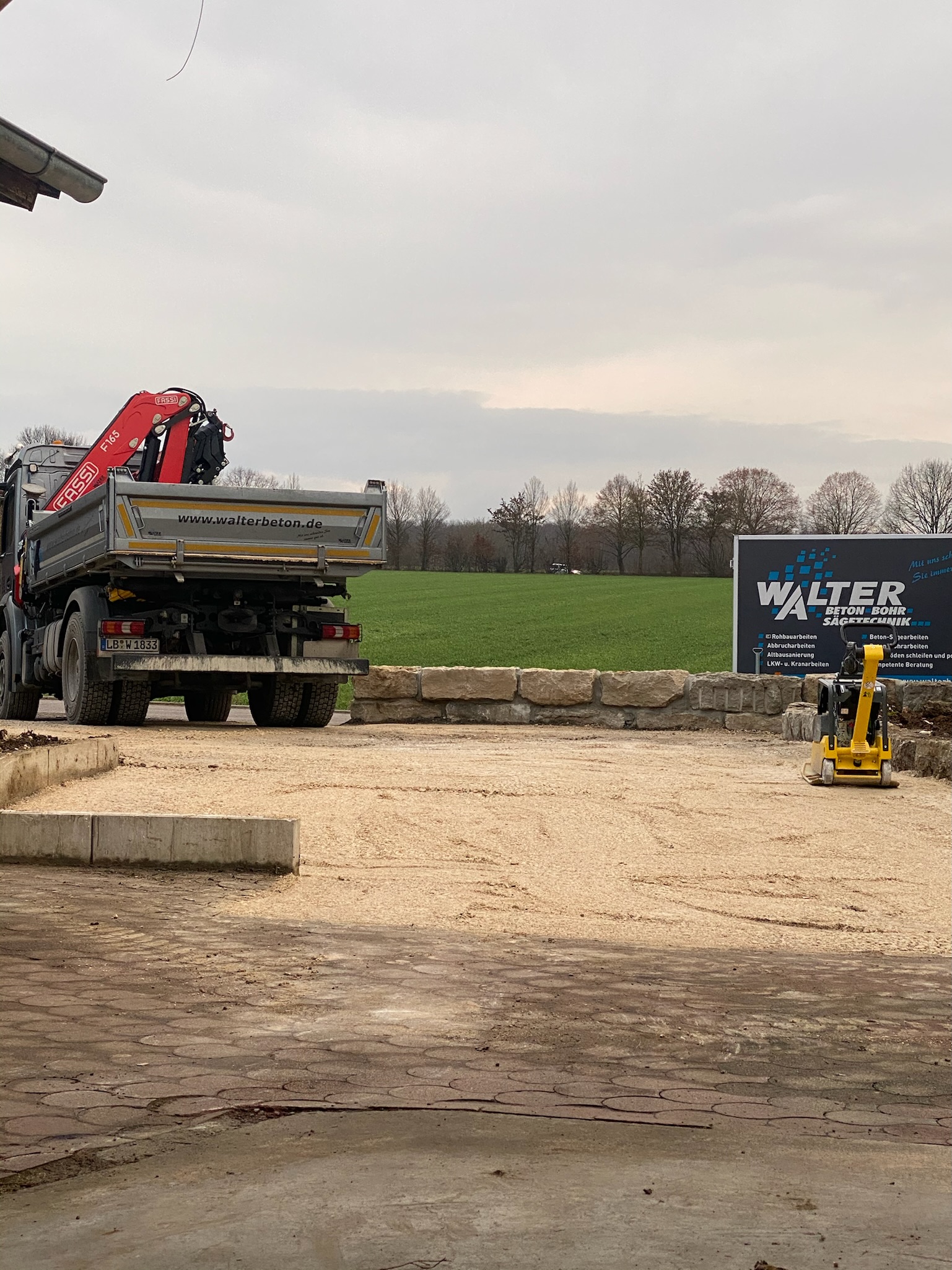 Walter-LKW mit Ladekran und Kompaktbagger auf einem Bauplatz in Remseck am Neckar