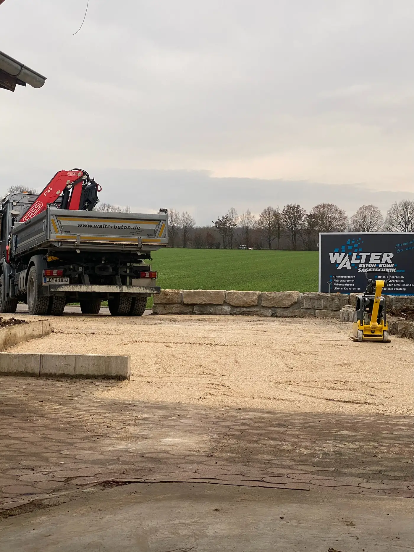Walter-LKW mit Ladekran und Kompaktbagger auf einem Bauplatz in Remseck am Neckar