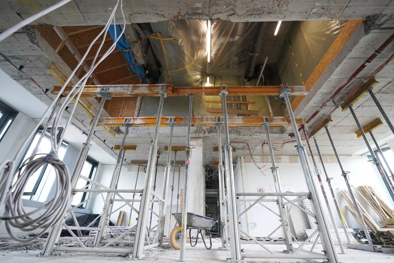 Baustützen sichern eine rechteckige Deckenöffnung in einer Stahlbetondecke