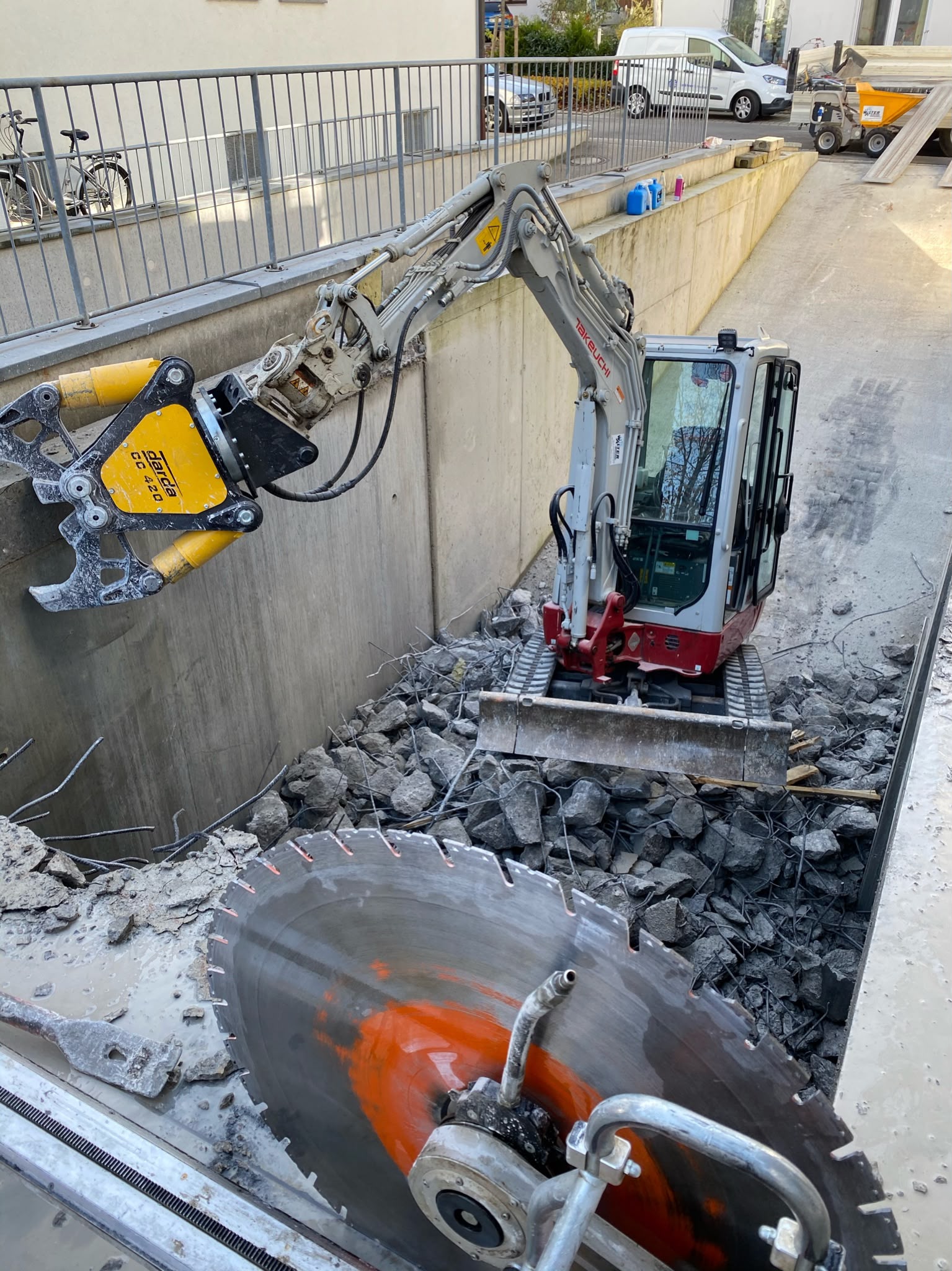 Hydraulische Betonzange am Minibagger beim Beton-Crashen einer Stützwand